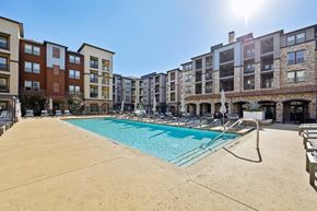 Mckinney apartment for rent - A sunny day at a pool in front of apartment buildings.