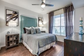 Dallas apartment for rent - a bedroom with a large bed and a ceiling fan