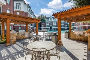 Dallas apartment for rent - an outdoor patio with tables and chairs and a pool