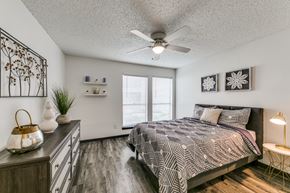Dallas apartment for rent - a bedroom with a bed and a ceiling fan