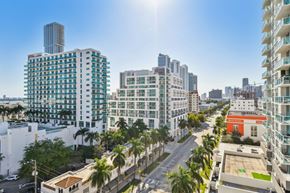 Miami apartment for rent - an aerial view of a city street with tall buildings and palm trees