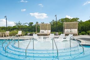 Gallatin townhouse for rent - A round swimming pool with a metal railing and white lounge chairs.