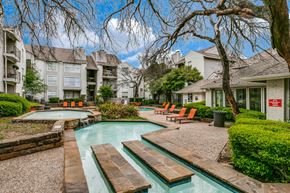 Dallas apartment for rent - a swimming pool with a fountain in front of a building