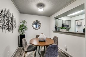 Dallas apartment for rent - a dining room area with a table and chairs and a mirror