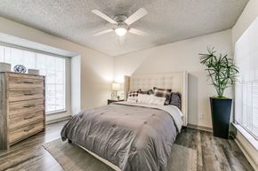 Dallas apartment for rent - a bedroom with a bed and a ceiling fan