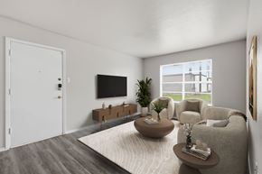 Stephenville apartment for rent - A living room with a grey sofa, a wooden coffee table, a flat screen TV, and a large window.