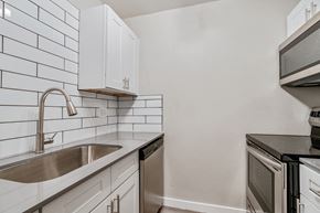 Phoenix apartment for rent - a kitchen with white cabinets and black countertops