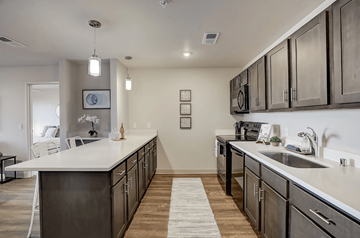 Middleton apartment for rent - A modern kitchen with dark wood cabinets and white countertops.