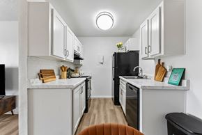 El Paso apartment for rent - A kitchen with white cabinets and a black refrigerator.