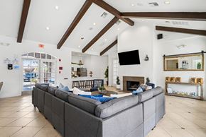 El Paso apartment for rent - A grey couch in a spacious room with a fireplace and a flat screen TV mounted on the wall.