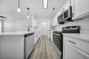 El Paso apartment for rent - A modern kitchen with white cabinets and black appliances.