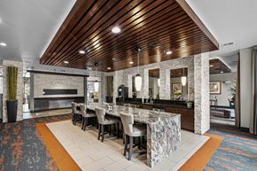 Houston apartment for rent - a large kitchen with a marble counter top and a long table with chairs