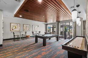 Houston apartment for rent - a spacious game room with a pool table and a bar