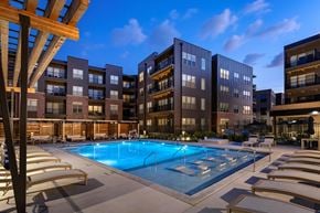 Omaha apartment for rent - A swimming pool surrounded by sun loungers and apartment buildings.