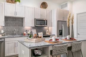 Dallas apartment for rent - A kitchen with a table set for two with plates and glasses.