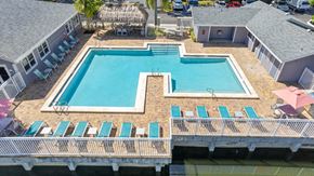 North Lauderdale apartment for rent - A large swimming pool surrounded by lounge chairs and umbrellas.