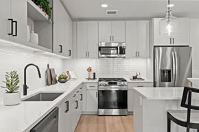 Gilbert apartment for rent - A modern kitchen with a stainless steel refrigerator and a black chair.