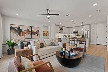Gilbert apartment for rent - A modern living room with a large painting on the wall and a coffee table in the center.