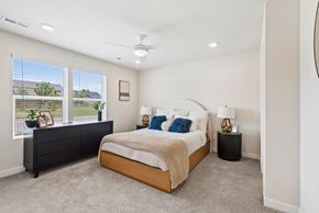 Denver townhouse for rent - A bedroom with a large bed and a window with a view of a fence and trees.