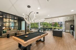 Houston apartment for rent - A pool table is in the middle of a room with a kitchen in the background.
