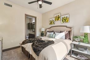 Houston apartment for rent - A bedroom with a large bed and a ceiling fan.