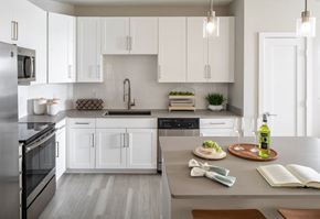 Tampa apartment for rent - A modern kitchen with white cabinets and stainless steel appliances.