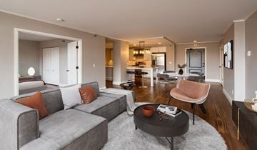 Minneapolis apartment for rent - A grey couch with orange pillows sits in a modern living room.