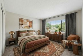 Hillsborough townhouse for rent - A bedroom with a large bed and a chair.