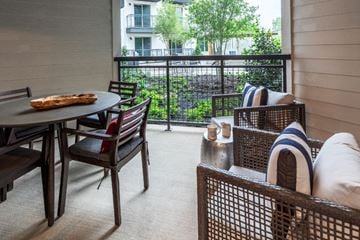 Dallas apartment for rent - a living room with a table and chairs and a balcony