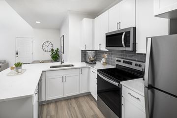 Irving apartment for rent - A modern kitchen with white cabinets and stainless steel appliances.