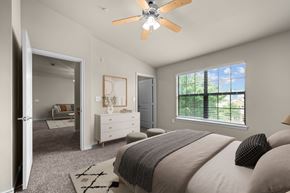 Waco apartment for rent - A bedroom with a large bed and a ceiling fan.