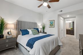 Rosenberg apartment for rent - A bedroom with a bed, nightstand, and a ceiling fan.