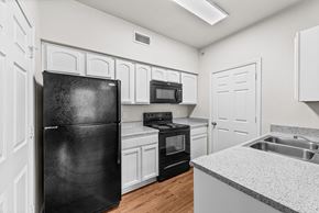 Killeen apartment for rent - the preserve at ballantyne commons apartment kitchen with black appliances and white cabinets