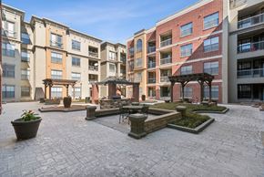 Houston apartment for rent - A courtyard with a brick floor and a building in the background.