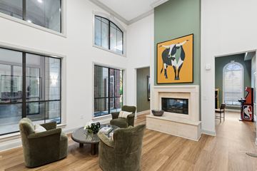 Houston apartment for rent - A living room with a fireplace and a painting of a cow on the wall.