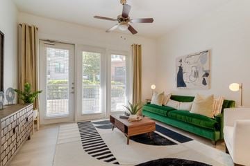 Charlotte apartment for rent - A living room with a green couch and a ceiling fan.