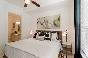 Charlotte apartment for rent - A bedroom with a large bed and a ceiling fan.