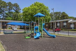 Forest Park apartment for rent - a playground with slides and a swing set in front of a building