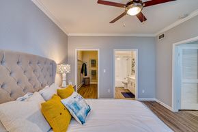 Houston apartment for rent - a bedroom with a large bed and a ceiling fan