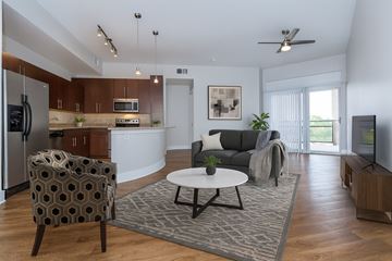 Dallas apartment for rent - A modern living room with a grey sofa and a patterned armchair.