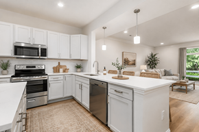 Grove City townhouse for rent - A modern kitchen with white cabinets and stainless steel appliances.