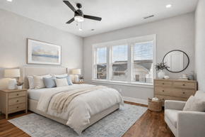 Spring Hill apartment for rent - A bedroom with a large bed, a ceiling fan, and a painting on the wall.