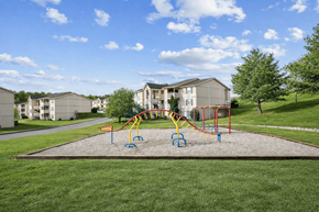 Dickson apartment for rent - A playground with a slide and swings in front of apartment buildings.