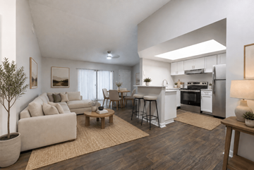North Lauderdale apartment for rent - A modern living room with a white couch, a wooden coffee table, and a kitchen area in the background.