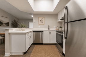 North Lauderdale apartment for rent - A modern kitchen with white cabinets and stainless steel appliances.