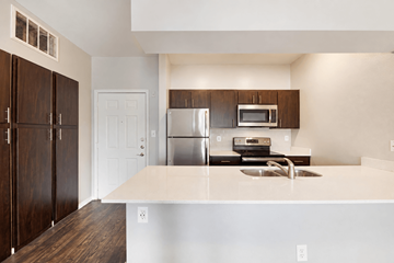Dallas apartment for rent - A kitchen with a white counter top and a stainless steel refrigerator.