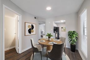 Houston apartment for rent - A dining room with a table set for two and a potted plant.