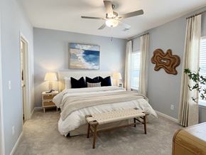 Pooler townhouse for rent - A bedroom with a large bed and a ceiling fan.