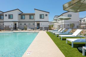 Phoenix apartment for rent - A swimming pool is surrounded by sun loungers and umbrellas.