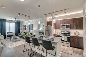 San Antonio apartment for rent - A modern kitchen with dark wood cabinets and a white island.